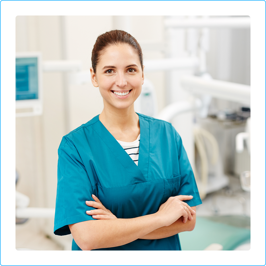 Denturologiste souriante en sarrau turquoise dans une clinique, illustrant la carriere de denturologiste au Quebec.