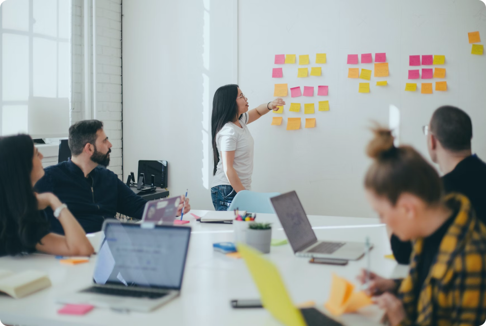 Une équipe de personnes utilisant des ordinateurs portables, travaillant activement ensemble dans un espace de bureau professionnel.